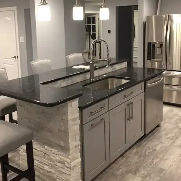 Modern kitchen with island, lights, and stainless appliances.