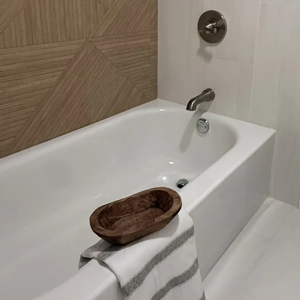 Modern bathtub with wooden decor and towel
