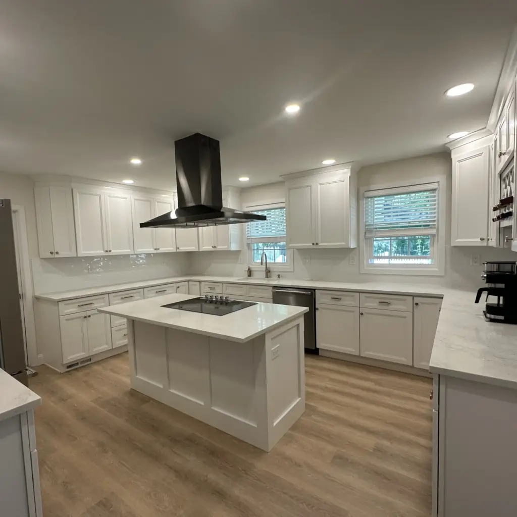 Modern white kitchen with island and hood vent.