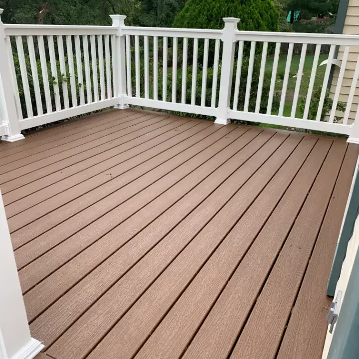 Spacious wooden deck with white railing.